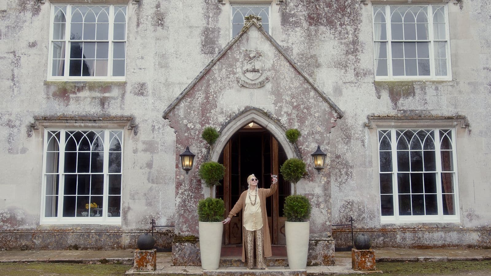 A welcoming figure at a manor house doorway